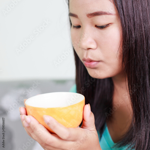 Asian woman drinking hot coffee