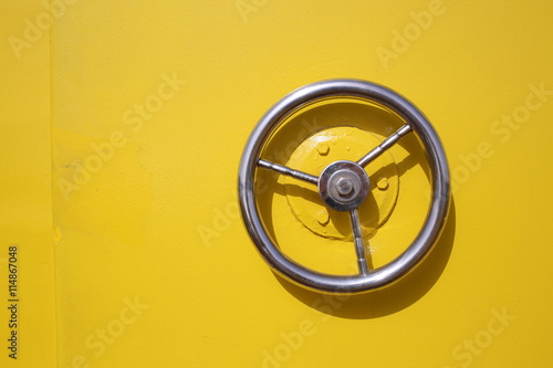 Iron circle wheel on the door of yellow ship