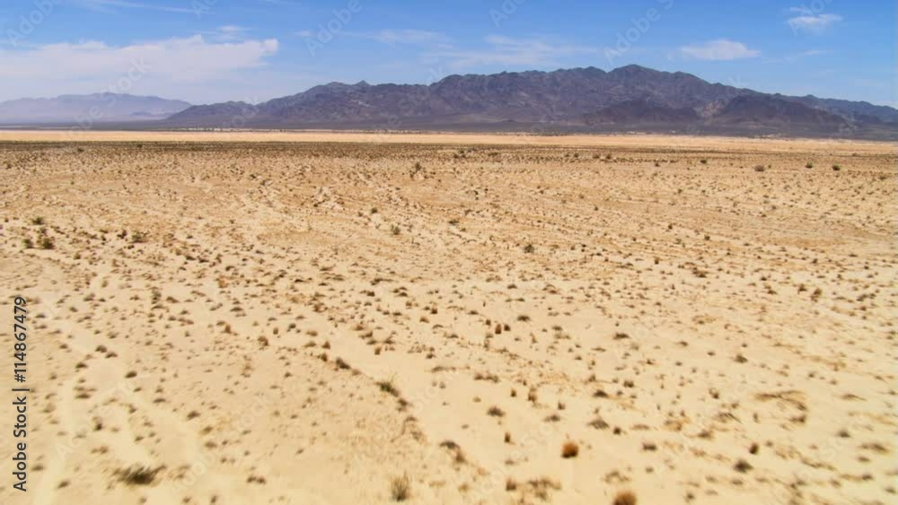 Low flight over desert toward rocky hills Low flight over desert toward rocky hills