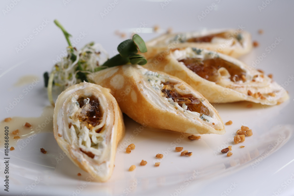 Food pancake with cream cheese, greens and jelly on a white plate, molecular cuisine, closeup. Food pancake with cream cheese, greens and jelly on a white plate, molecular cuisine, closeup.