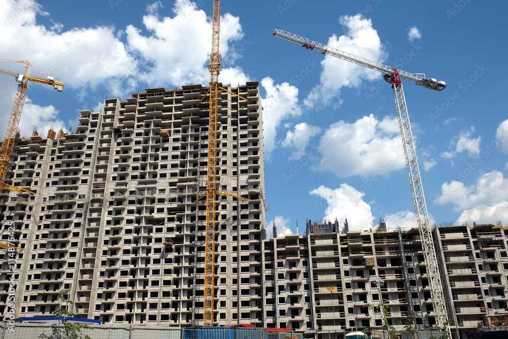 Fototapeta premium New high-rise modern apartment buildings construction in process ob bright sunny day front view horizontal