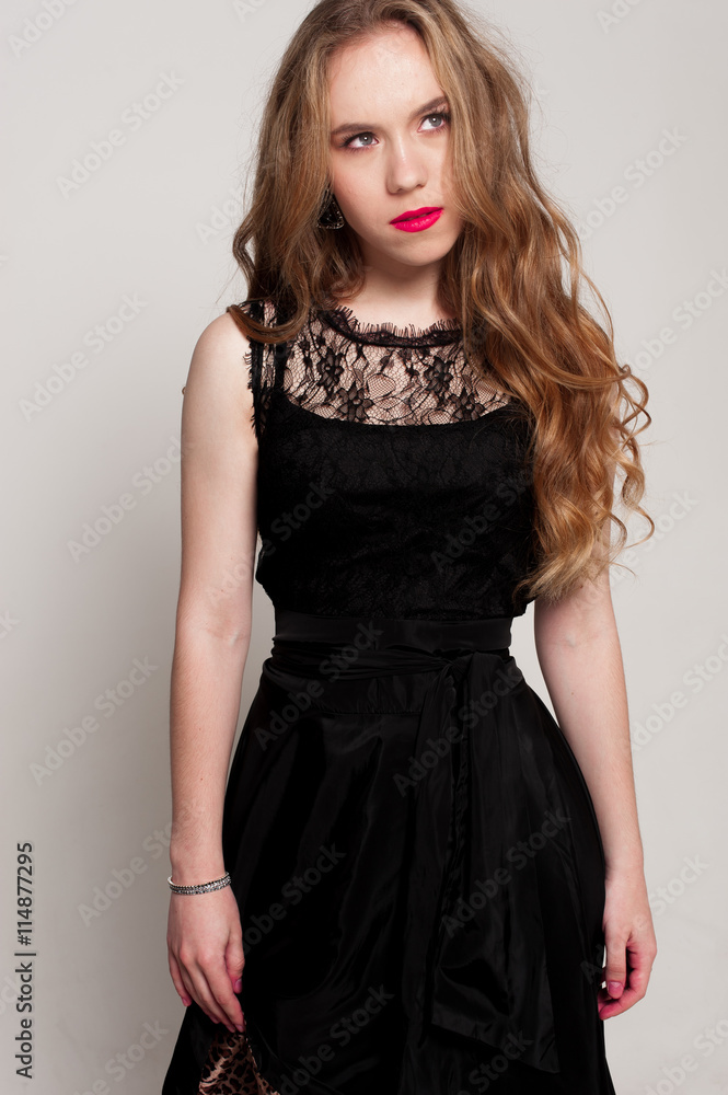 Portrait of beautiful young blonde girl in black dress. Fashion photo Portrait of beautiful young blonde girl in black dress. Fashion photo