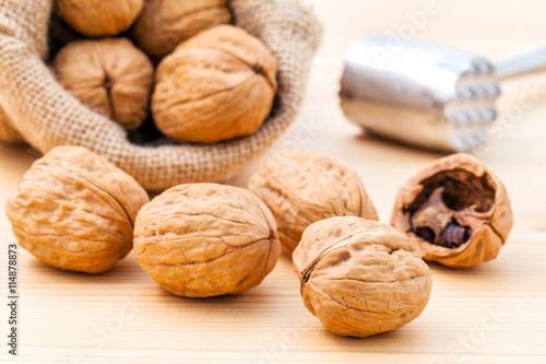 Walnuts kernels and whole walnuts on wooden background. Whole an