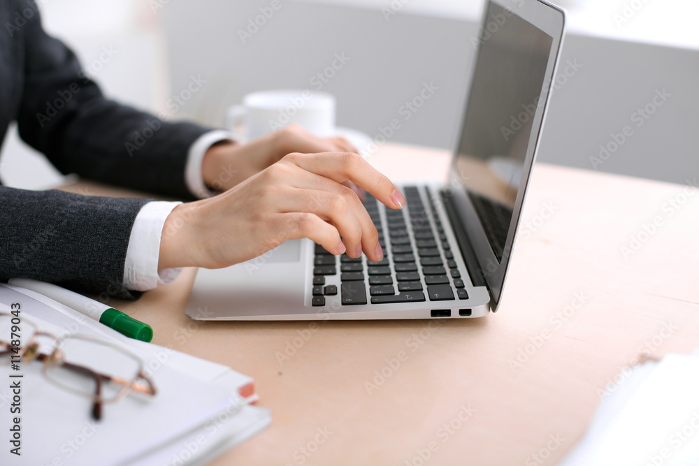 Close up of business woman hands typing on laptop computer in the white colored office. Close up of business woman hands typing on laptop computer in the white colored office.