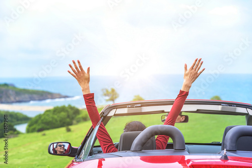 Girl in a red convertible car.