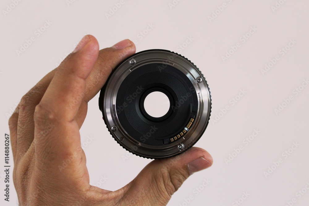 A DSLR camera lens in a man's hand A DSLR camera lens in a man's hand