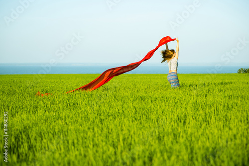 Young lady runing with tissue in green field. Beautiful happy woman walking in the summer rural meadow. Beautiful fit tan girl. Sexy slim model caucasian ethnicity outdoors.