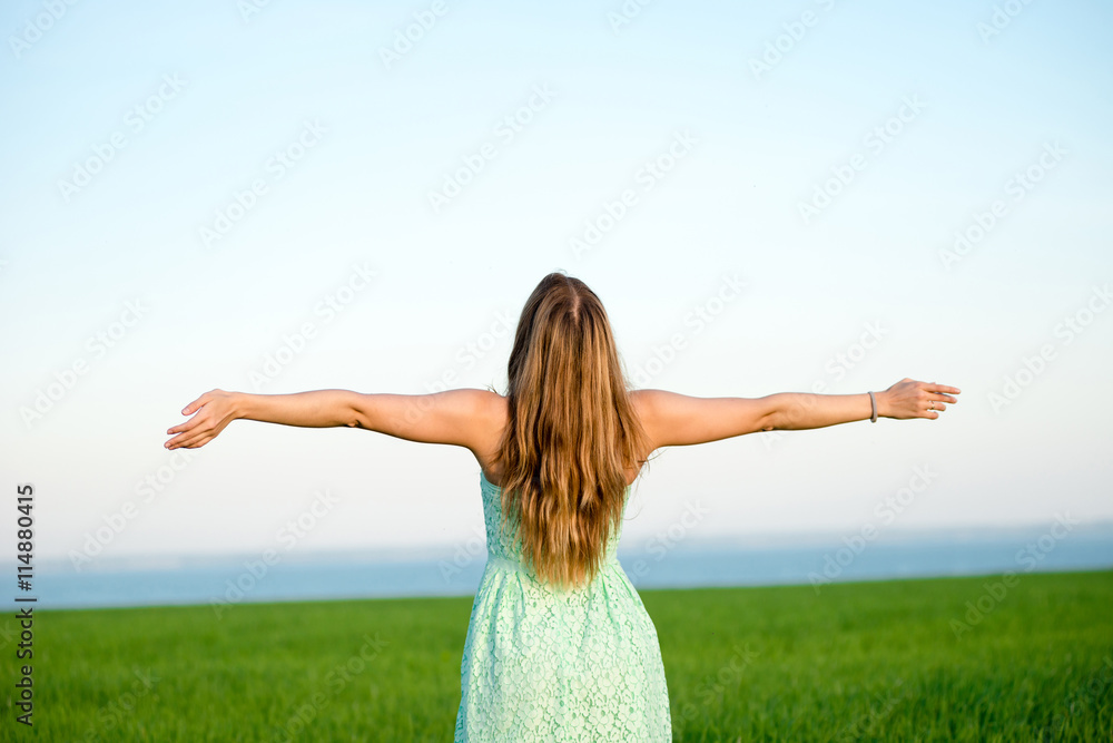 Happiness woman stay outdoor under sunlight of sunset. With raised hands at the sunrise time. Happiness woman stay outdoor under sunlight of sunset. With raised hands at the sunrise time.