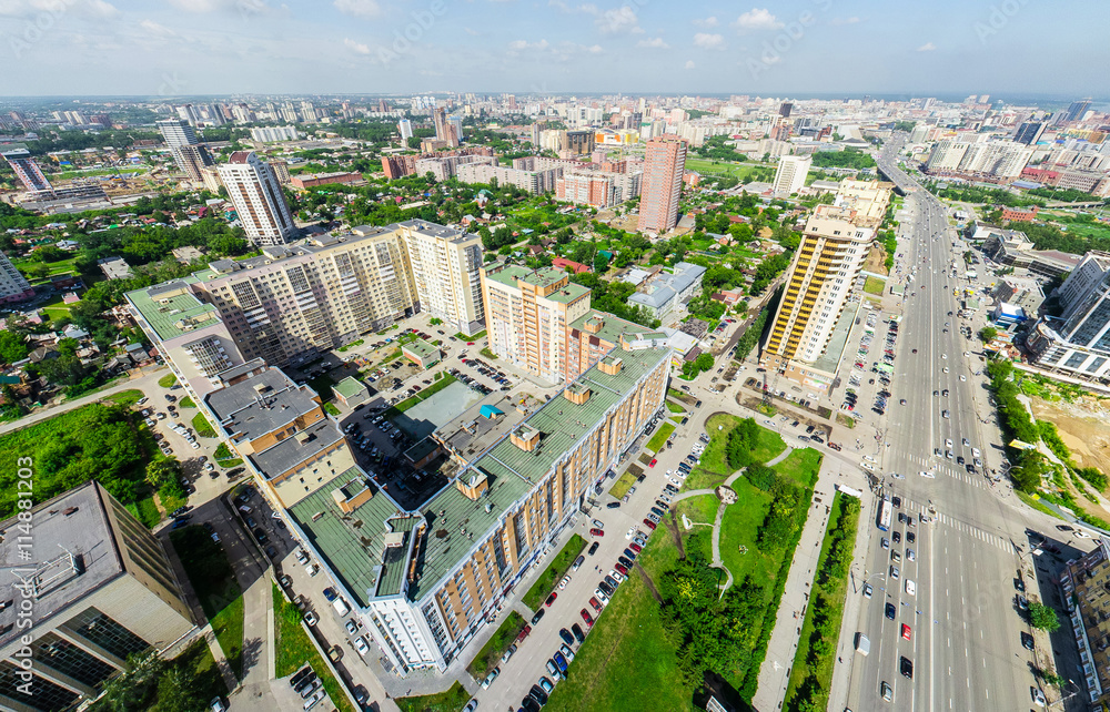Fototapeta premium Aerial city view with crossroads and roads, houses, buildings, parks and parking lots, bridges. Copter shot. Panoramic image.