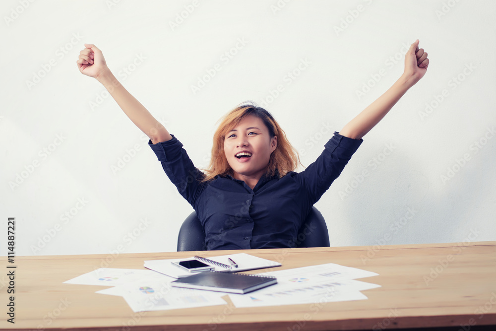 happy and successful business woman with her arms raised working happy and successful business woman with her arms raised working