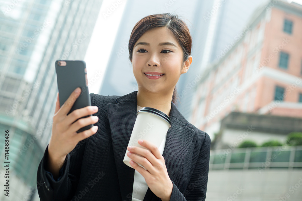 Business woman use of cellphone and holding a coffee Business woman use of cellphone and holding a coffee