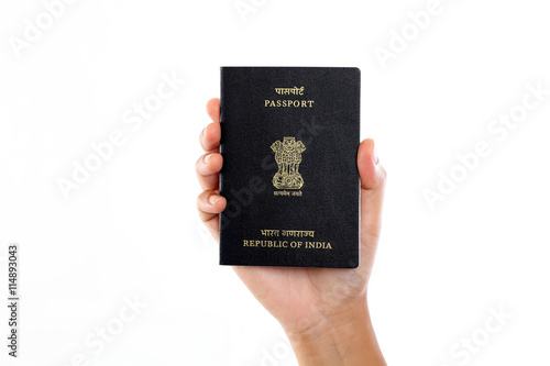 Hand holding Indian passport against white background