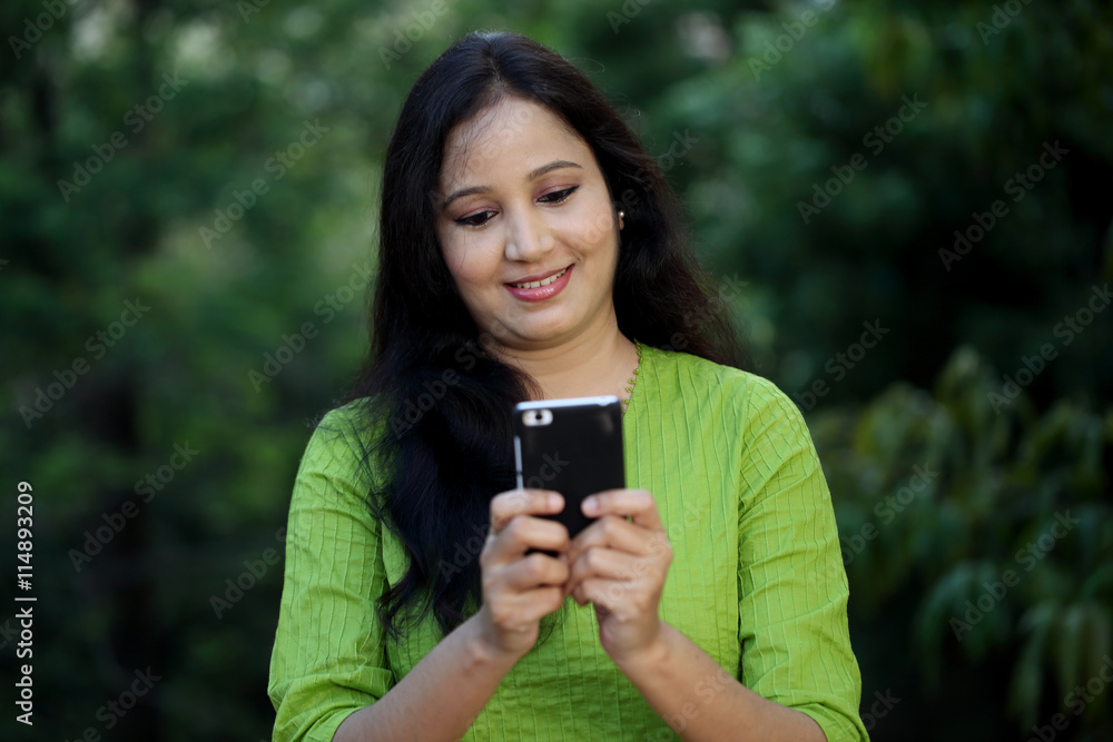 Happy young woman text messaging at outdoors Happy young woman text messaging at outdoors