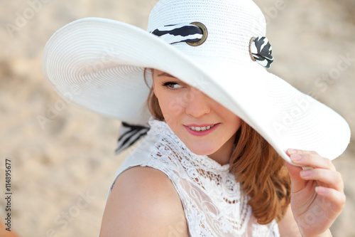 Молодая девушка в шляпе на пляже