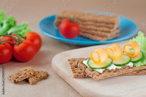 Close up of crispbreads with cheese, cucumber and carrot