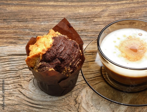 Chocolate muffins and cup of coffee on wooden background