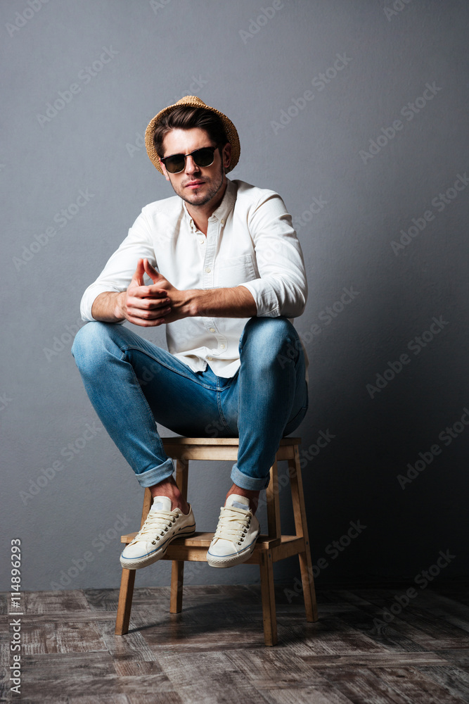 Full length of attractive young man in sunglasses and hat Full length of attractive young man in sunglasses and hat