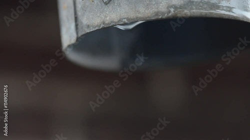 Falling water drops from eaves at wintertime