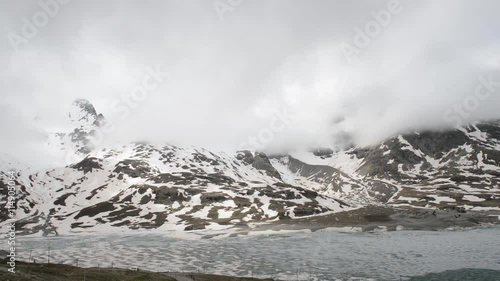 alpine landscape with peaks covered by snow and clouds at swiss alps