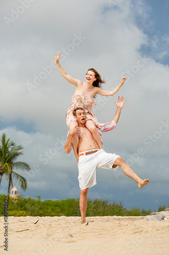 Happy couple walking on the beach. keeping balance