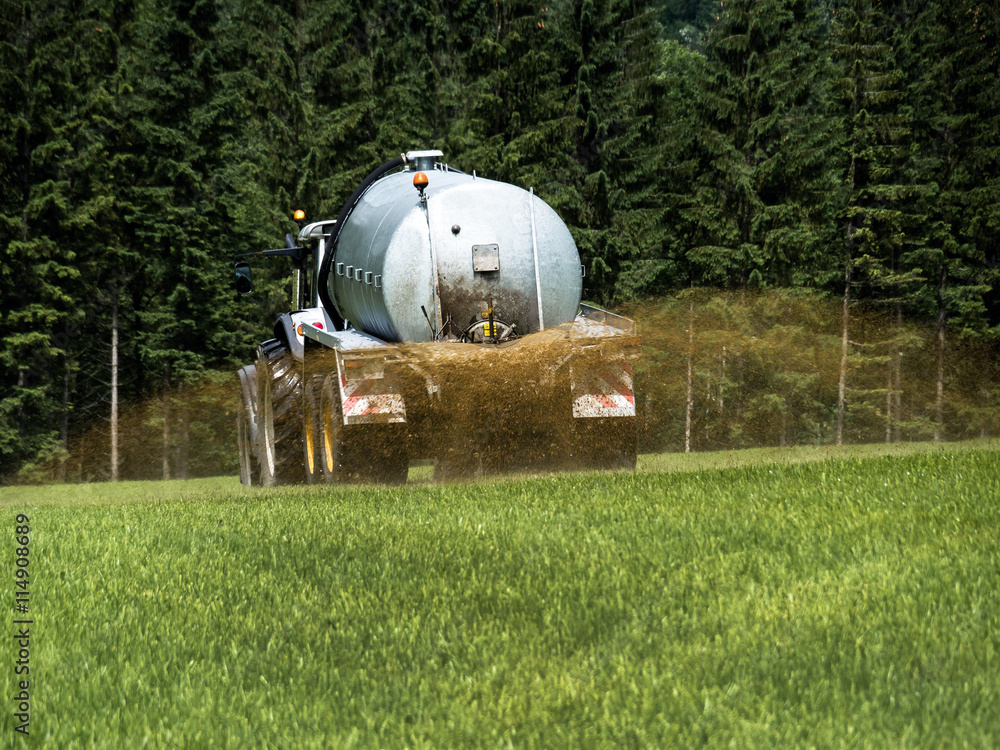 Bauer düngt ein Feld mit Gülle Bauer düngt ein Feld mit Gülle