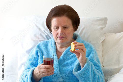 Seniorin trinkt Tee mit Zitrone