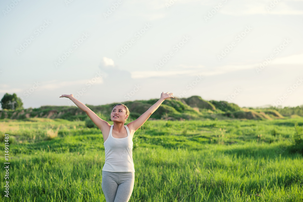 Happy beautiful woman with stretched arms in meadows with fresh Happy beautiful woman with stretched arms in meadows with fresh