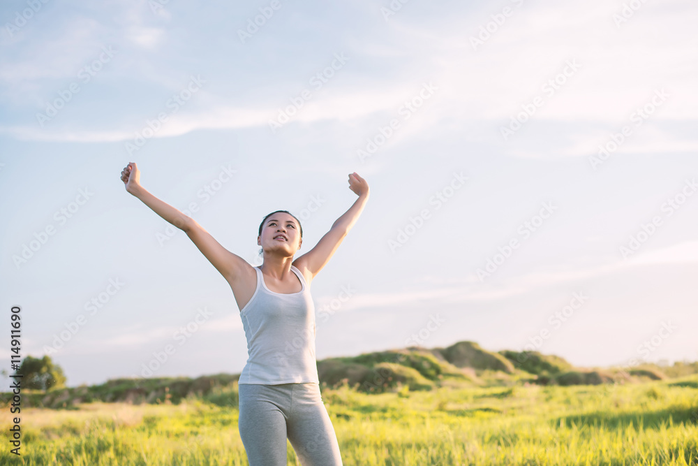 Happy beautiful woman with stretched arms in meadows with fresh Happy beautiful woman with stretched arms in meadows with fresh