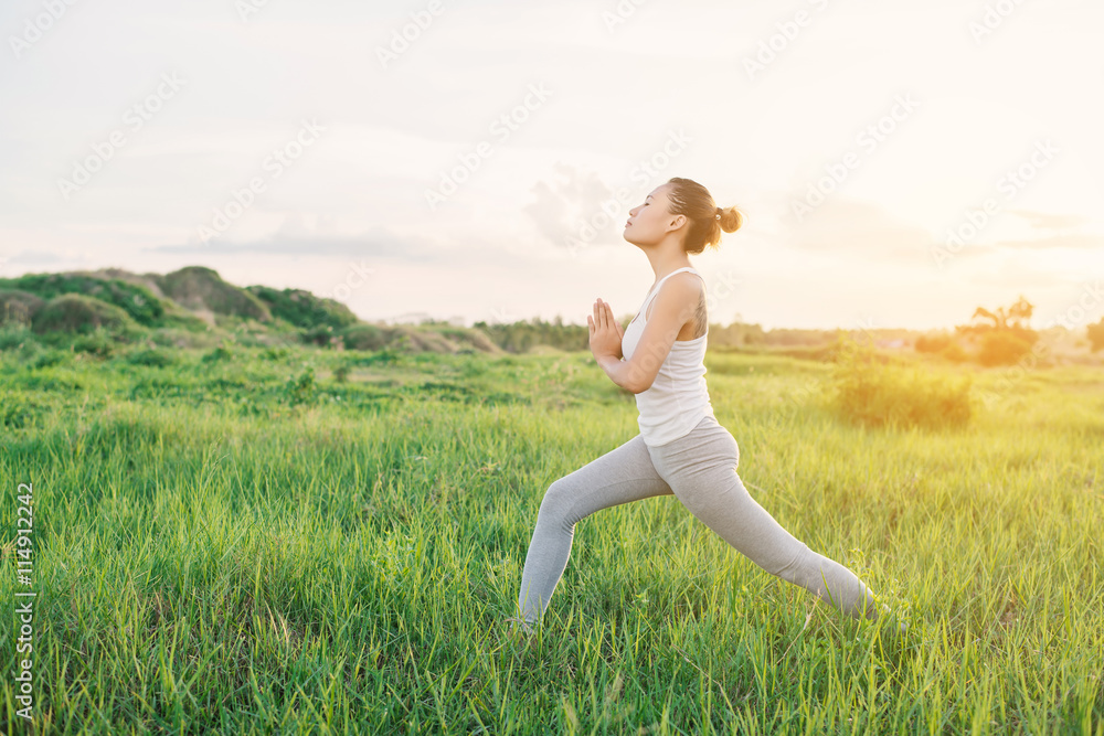 Young beautiful young woman doing yoga in the park in the mornin Young beautiful young woman doing yoga in the park in the mornin