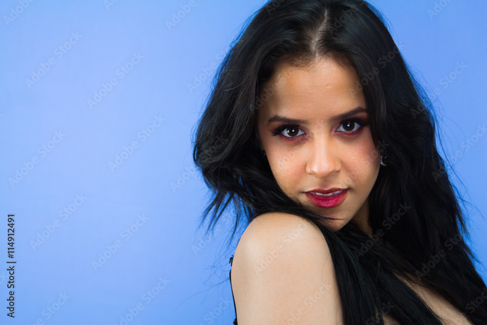 Woman looking into the camera on a blue background Woman looking into the camera on a blue background