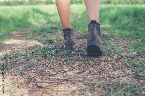 Young adventure woman feet walking on gravel in the countryside.