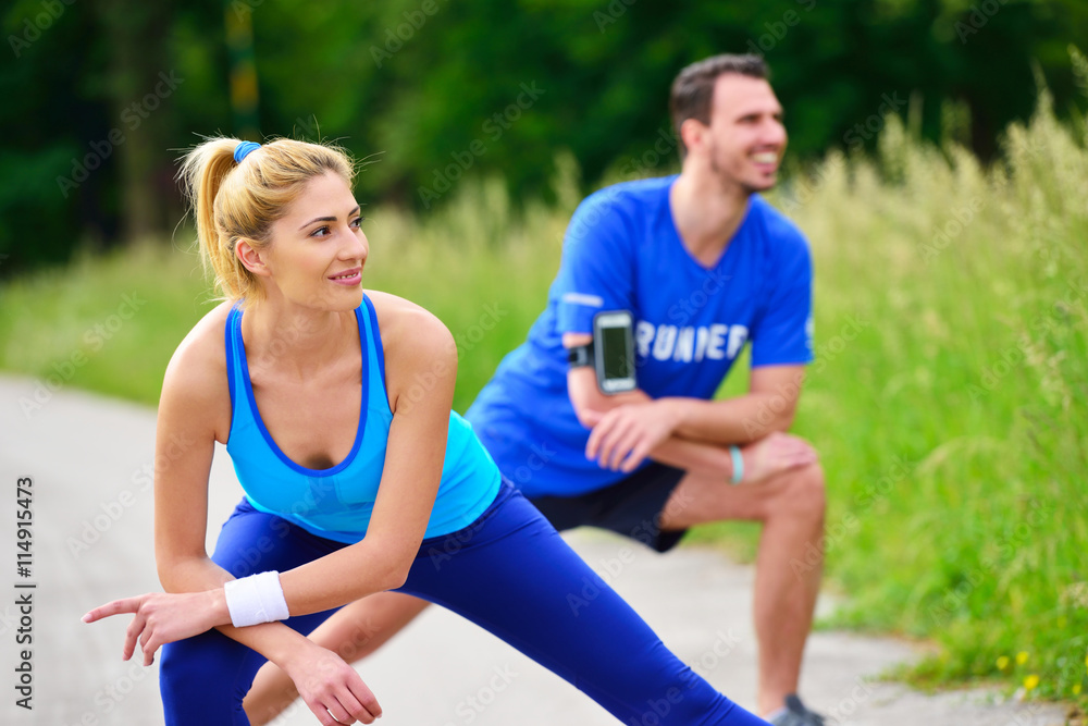 young health couple doing stretching exercise relaxing and warm up after jogging and running in park young health couple doing stretching exercise relaxing and warm up after jogging and running in park