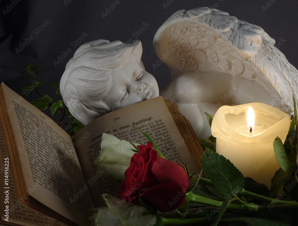 Schlafender Engel mit Bibel, Rosen und Kerze Stock-Foto | Adobe Stock