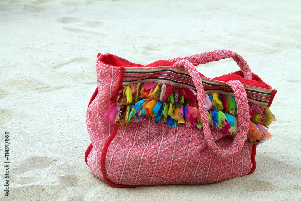 Naklejka premium multicolored beach bag on the sand