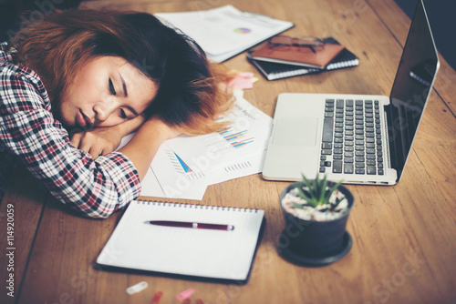 Young hipster woman tired for work and nap on workplace .