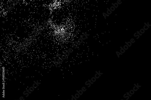 Abstract grainy texture isolated on black background. Silhouette of food flakes such as salt or almond or wheat flour spread on the flat surface or table. Top view. Dust, sand blow or bread crumbs.