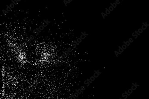 Abstract grainy texture isolated on black background. Silhouette of food flakes such as salt or almond or wheat flour spread on the flat surface or table. Top view. Dust, sand blow or bread crumbs.