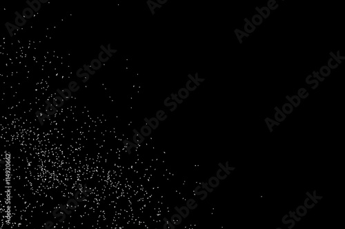 Abstract grainy texture isolated on black background. Silhouette of food flakes such as salt or almond or wheat flour spread on the flat surface or table. Top view. Dust, sand blow or bread crumbs.