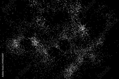 Abstract grainy texture isolated on black background. Silhouette of food flakes such as salt or almond or wheat flour spread on the flat surface or table. Top view. Dust, sand blow or bread crumbs.