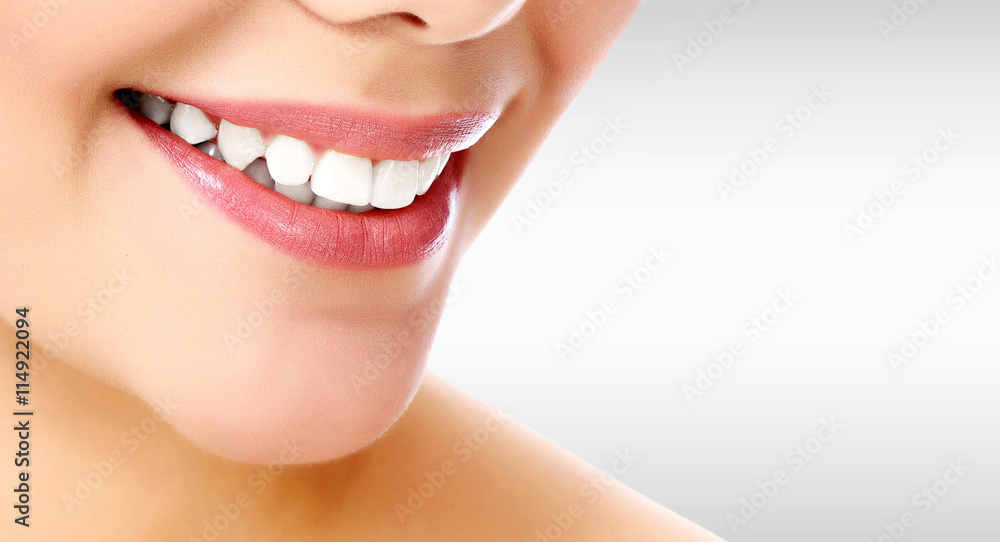 Obraz premium Pretty woman smiling against a grey background with copyspace