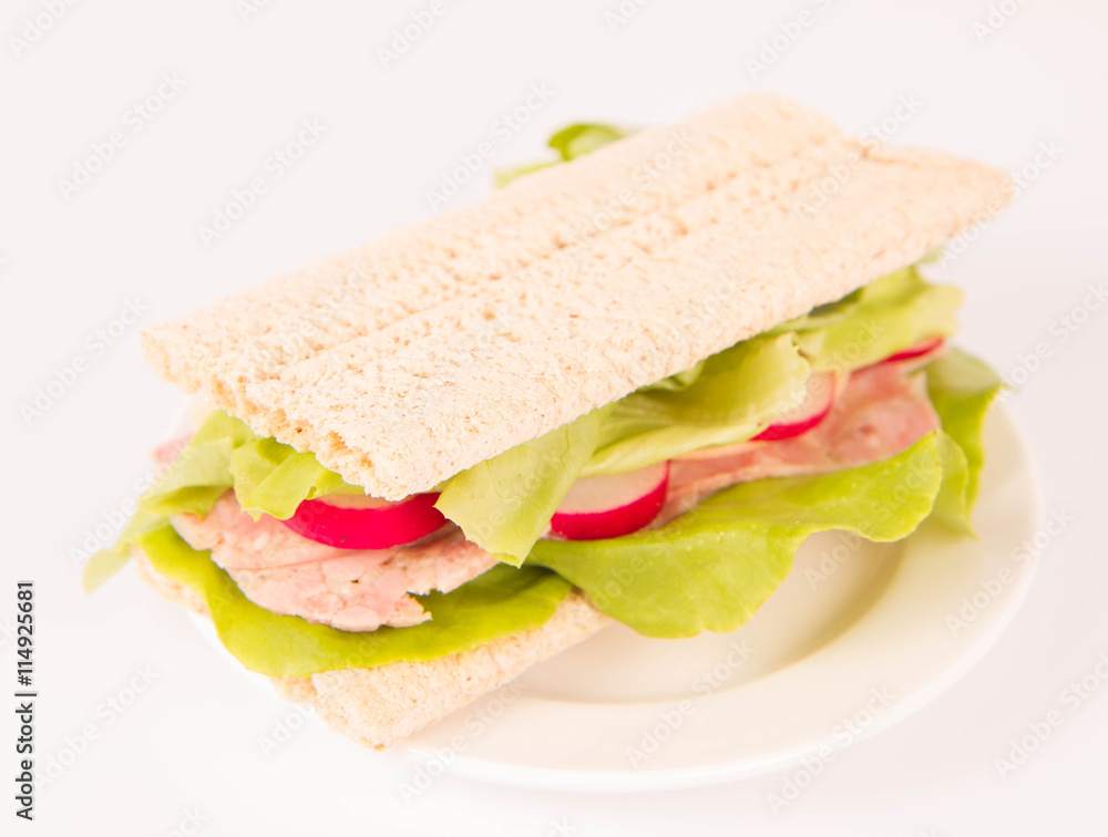 Crispbread sandwich with headcheese, cheese, radish and lettuce on a white background Crispbread sandwich with headcheese, cheese, radish and lettuce on a white background