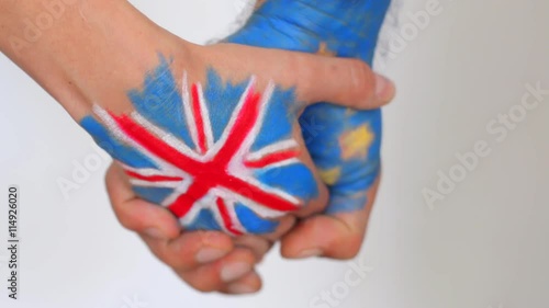 Hand patterned with the flag of the United Kingdom hold another hand patterned with the flag of the European Community photo