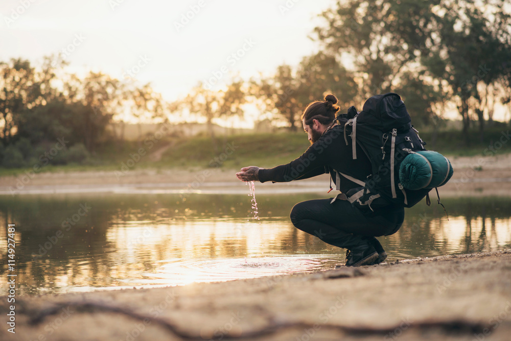 Obraz premium Backpacker at lake playing with water