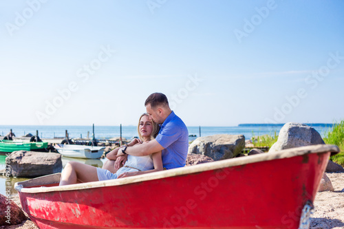 beautiful couple sitting in boat on summer beach © Di Studio