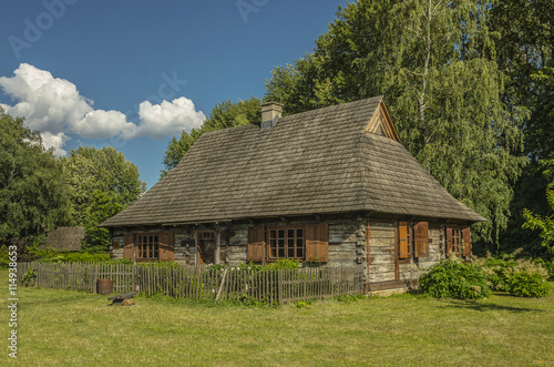 wiejska chata / wiejski domek z ogródkiem i okiennicami pod lasem 