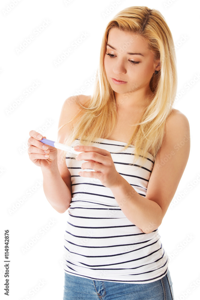 Steenage girl looking on pregnancy test- isolated on white. Steenage girl looking on pregnancy test- isolated on white.