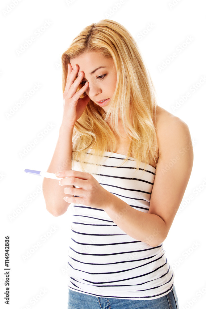 Steenage girl looking on pregnancy test- isolated on white. Steenage girl looking on pregnancy test- isolated on white.