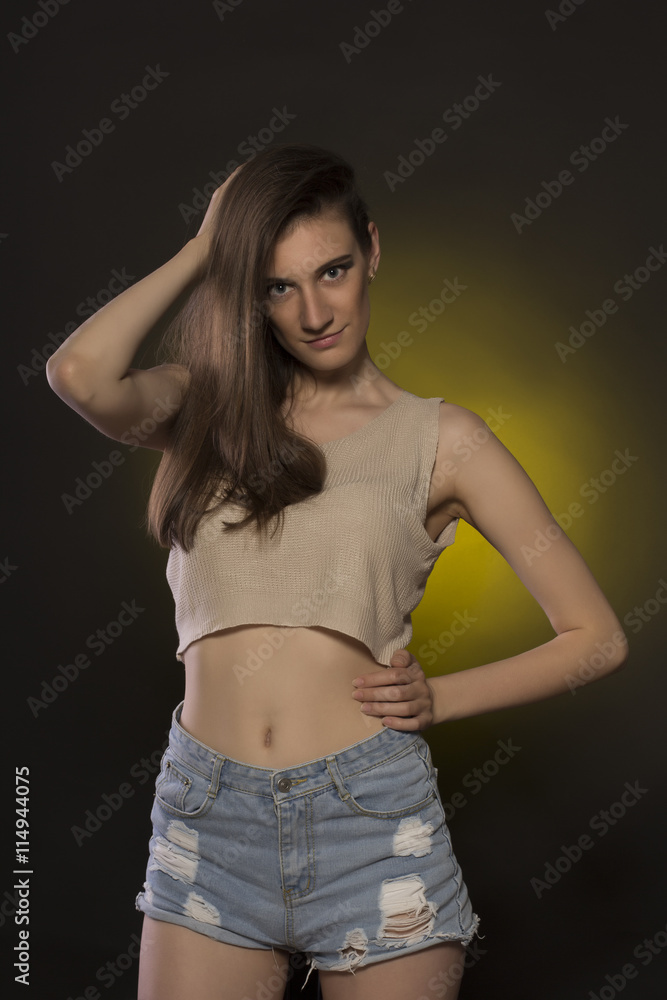 Attractive brunette woman in jeans shorts and crop top