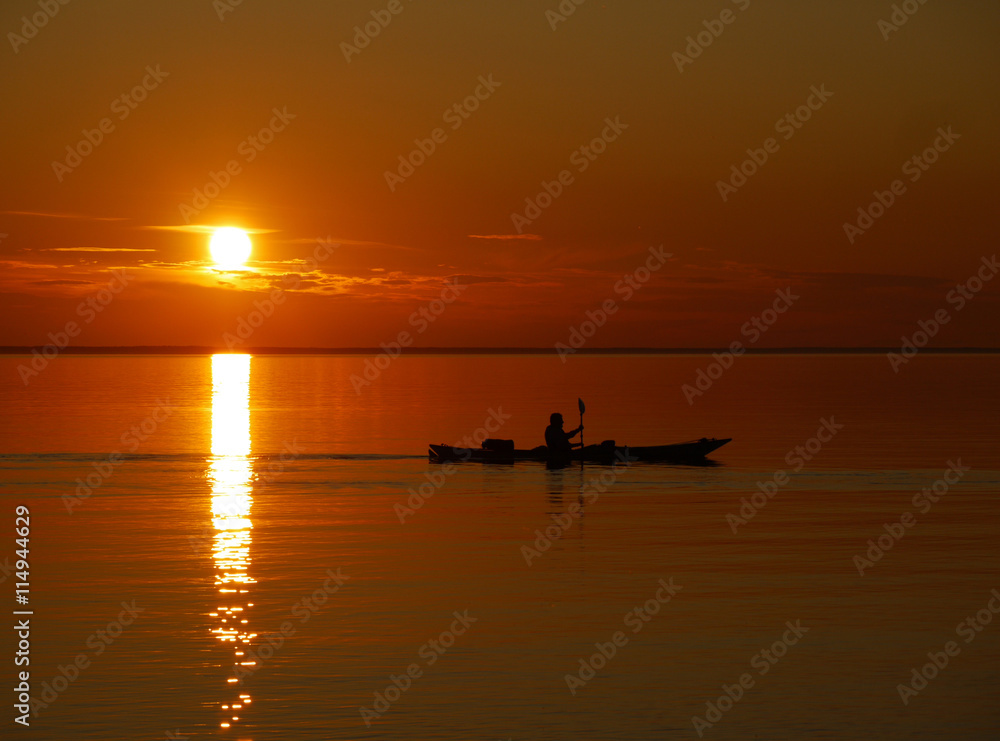 Fototapeta premium Paddler im Sonnenuntergang auf dem See
