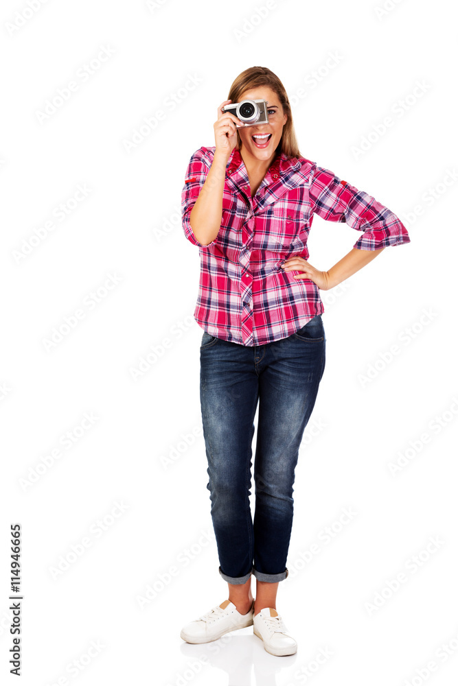 Young smiling woman making a photo through old photo camera Young smiling woman making a photo through old photo camera